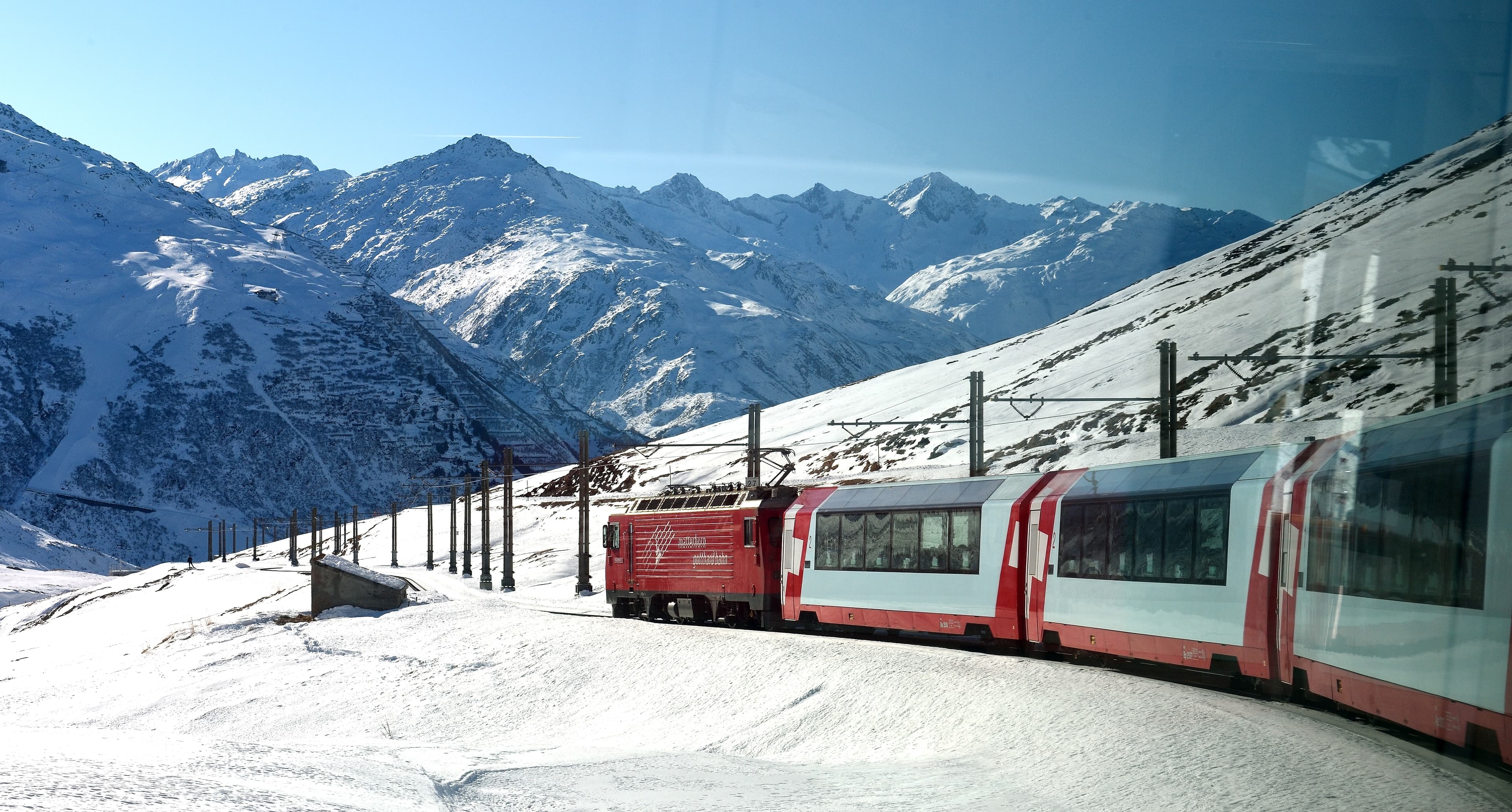 Glacier Express panoramic train traversing the high alpine valley near Andermatt